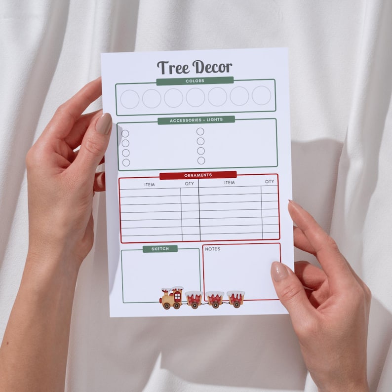 May include: A white Christmas tree decor planning sheet titled "Tree Decor". It features sections for colours, accessories, lights, ornaments, a sketch, and notes. A colourful train graphic is at the bottom of the sheet.