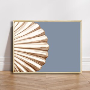 Puede incluir: Una impresión enmarcada de una concha con un esquema de color marrón claro y blanco sobre un fondo azul claro.