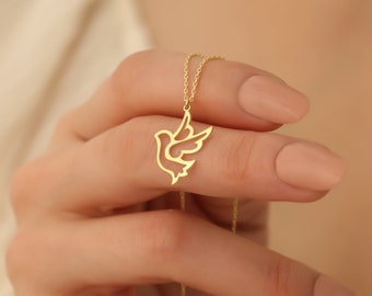 May include: A gold necklace with a delicate dove pendant. The dove is a symbol of peace and hope.