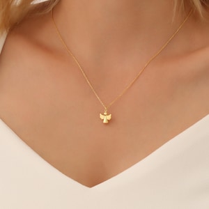 May include: A gold chain necklace with a small angel pendant.