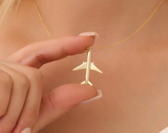 Op de afbeelding: Een gouden vliegtuig hanger ketting. De hanger is een eenvoudige silhouet van een vliegtuig.