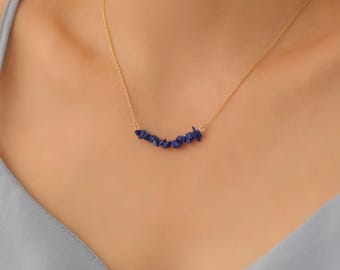 May include: A gold chain necklace with a delicate row of small, irregular blue lapis lazuli stones.
