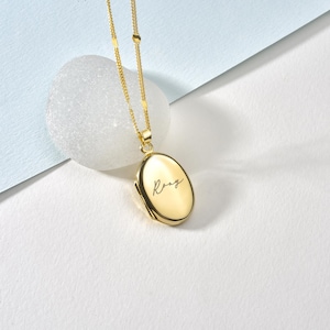 Puede incluir: Collar con dije ovalado de oro y cadena delicada. El dije está grabado con el nombre "Rory".