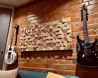 May include: Acoustic studio wall featuring a wooden geometric art piece and two electric guitars. The guitars are white and black, mounted on a red brick wall. The wooden art piece is made of small, angled wooden blocks.