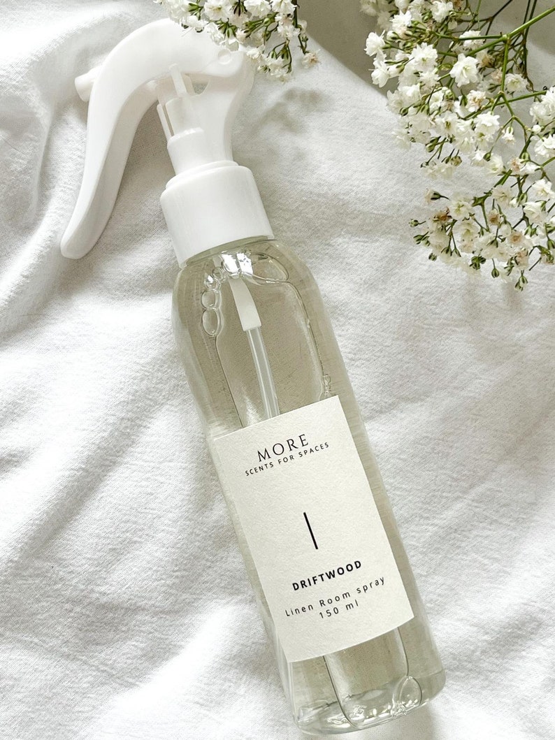 Peut inclure: Une bouteille en verre transparente avec une buse de pulv&eacute;risation blanche et une &eacute;tiquette blanche. L'&eacute;tiquette indique "MORE SCENTS FOR SPACES" et "DRIFTWOOD Linen Room spray 150 ml".