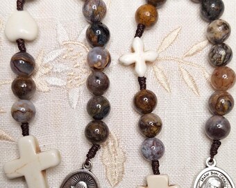 May include: A brown and white rosary with a heart, cross, and chalice charm. The beads are made of agate and the charms are made of wood.