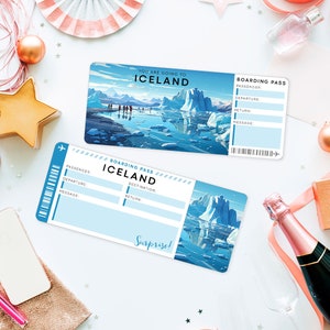 May include: Two blue and white boarding passes with the text "You are going to Iceland" and "Boarding Pass Iceland" on them. The passes are on a white surface with gold stars, pink ribbon, and a champagne bottle.