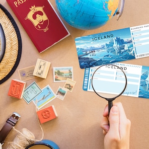 May include: Two blue and white boarding passes with the text "You are going to Iceland" and "Boarding Pass" on them. The passes are on a brown surface with a magnifying glass, a straw hat, stamps, and a globe.