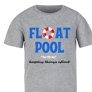 Könnte beinhalten: Ein meliertes graues T-Shirt mit den Worten "FLOAT POOL" in Blau, einer rot-weißen Rettungsring-Grafik und dem Text "The Fill-ins" und "keeping things afloat" in Schwarz. Ein lässiges Kleidungsstück.