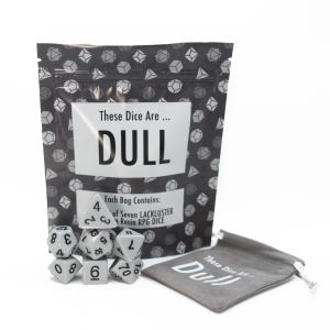 May include: A set of seven resin RPG dice in a gray color, displayed with a matching gray drawstring bag. The dice are next to a larger bag with the text "These Dice Are... DULL". The larger bag has a geometric pattern.