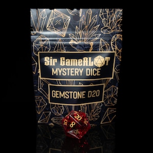 May include: A red gemstone D20 die with gold numbering sits in front of a black pouch. The pouch has gold crystal designs and the text "Sir GameALot Mystery Dice GEMSTONE D20".