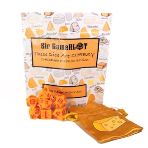 May include: A seven-piece orange resin RPG dice set with red numbering, packaged in a white pouch featuring a cheese pattern and the text Sir GameALot These Dice Are CHEESY CHEDDAR CHEESE Edition, alongside a gold drawstring bag with a cheese graphic.