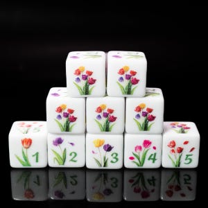 May include: A set of white square dice arranged in a pyramid formation. Each die features a colorful tulip illustration and a green number. The dice are stacked with three on the bottom, three in the middle, and two on the top, all against a black background.
