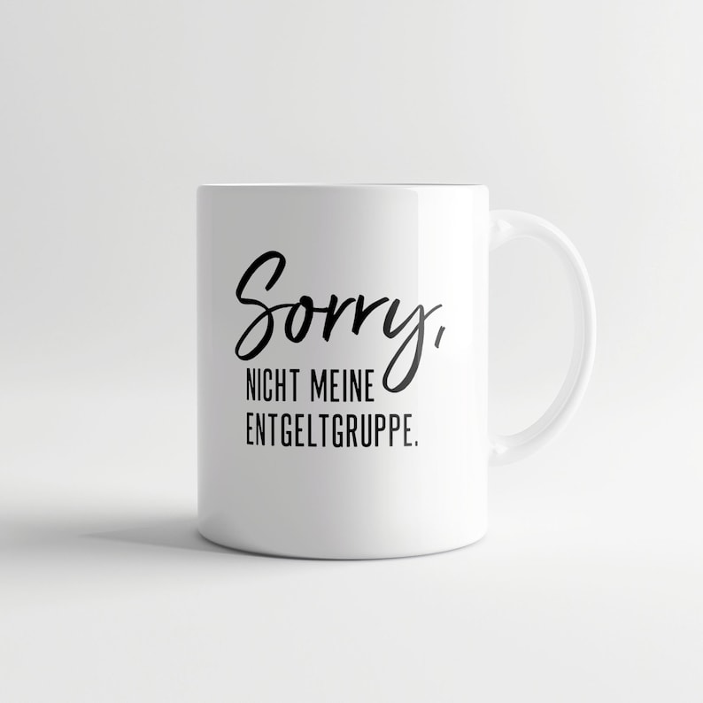 K&ouml;nnte beinhalten: Wei&szlig;e Keramiktasse mit schwarzem Text, der "Sorry, nicht meine Entgeltgruppe." lautet.