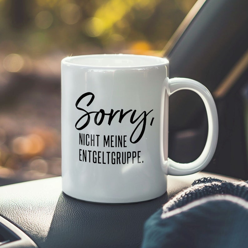 K&ouml;nnte beinhalten: Wei&szlig;e Keramiktasse mit schwarzem Text, der "Sorry, nicht meine Entgeltgruppe." lautet.