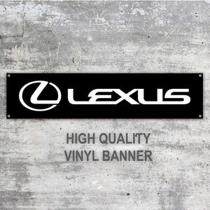 May include: Black rectangular vinyl banner featuring the white Lexus logo and text. The banner reads "HIGH QUALITY VINYL BANNER" in white text. The banner is mounted on a grey concrete wall.