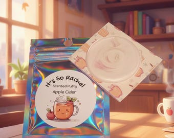 Könnte beinhalten: Ein holografischer Beutel mit duftender Knete, beschriftet mit It's So Rachel Apple Cider, zeigt eine Illustration einer lächelnden Tasse Apfelwein und einen Apfel. Eine quadratische Karte mit kreisförmigem Ausschnitt zeigt die weiße Knete.