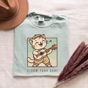 Strum Your Soul PNG, Cat Playing Guitar PNG, Guitarist cat PNG, Music lover png