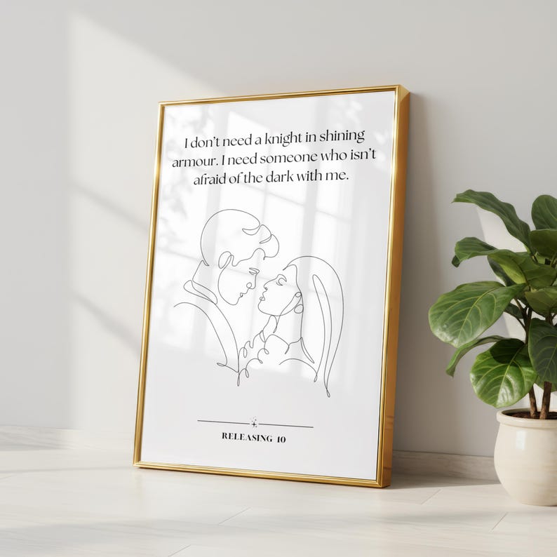 May include: A framed wall art print featuring a continuous line drawing of a couple facing each other. The text reads: I don't need a knight in shining armour. I need someone who isn't afraid of the dark with me. Below is a line and the text RELEASING 10.