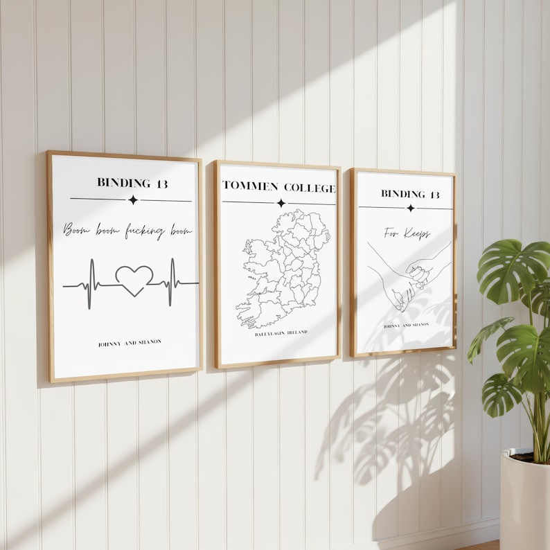 May include: Three framed vertical wall art prints with white backgrounds and black text. The first features 'BINDING 13', 'Boom boom fucking boom', a heartbeat line, and a heart. The second shows a map of Ireland labeled 'TOMMEN COLLEGE'. The third shows hands holding pinkies with 'BINDING 13' and 'For Keeps'.
