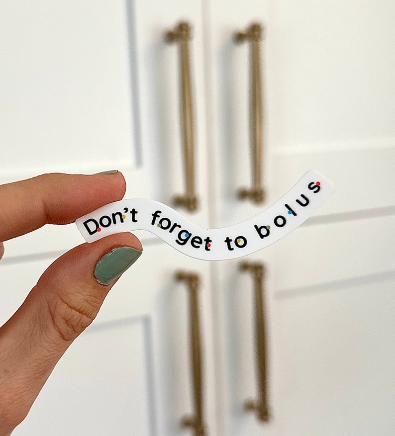 Pode incluir: Etiqueta branca com o texto "Don't forget to bolus" em letras pretas. A etiqueta &eacute; curva e tem pontos coloridos espalhados.