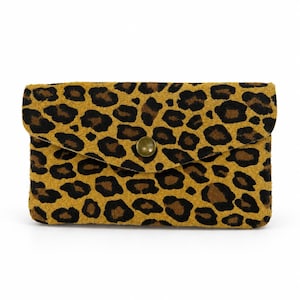 Può includere: Una pochette rettangolare con base giallo senape e motivo leopardato nero e marrone scuro. La borsa presenta una patta ripiegabile fissata da un singolo bottone metallico centrale con finitura opaca.