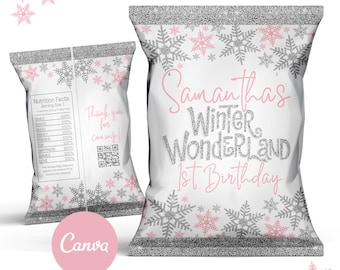 Op de afbeelding: Een witte chipzak met een zilveren glitterrand en roze sneeuwvlokken. De zak heeft de tekst "Samantha's Winter Wonderland 1st Birthday" in roze en zilveren glitter. De zak heeft ook een voedingswaarde-etiket en een bedankje met een QR-code.