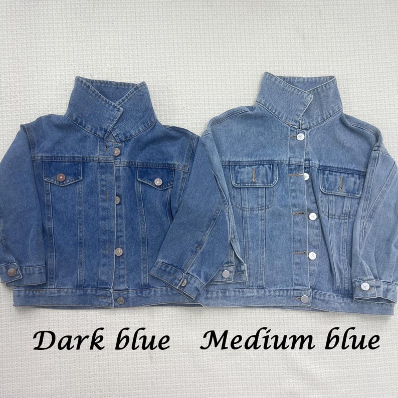 May include: Two denim jackets, one dark blue and one medium blue, with a button-up front and a collar.