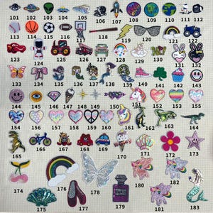 May include: A collection of 183 iron-on patches featuring a variety of designs, including animals, food, objects, and words. The patches are colorful and sparkly, and they are perfect for adding a personal touch to clothing, bags, and other accessories.