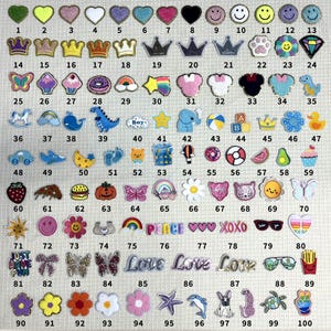 May include: A sheet of 100 iron-on patches featuring various designs, including hearts, crowns, animals, food, and words. The patches are colorful and come in a variety of shapes and sizes.