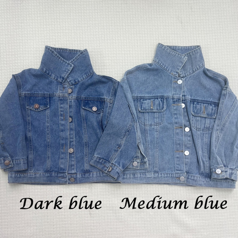 May include: Two denim jackets, one dark blue and one medium blue, with a button-up front and a collar.