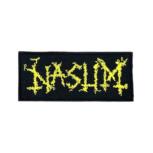 Puede incluir: Parche negro con la palabra "NASHIM" en amarillo, estilizada en una fuente gótica dentada.