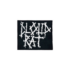 May include: A black rectangular patch featuring the white embroidered text "BLOOD RAT" in a gothic style. The patch has a black border and is set against a white background. The design is striking and would suit a jacket or bag.