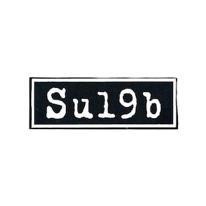 May include: Black and white rectangular patch with the text "Su19b" in white.