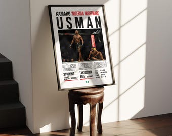 May include: A framed poster featuring Kamaru Usman, with the text "NIGERIAN NIGHTMARE" above his name. The poster includes images of Usman in a fighting stance, along with statistics for striking and takedown accuracy. The poster is displayed on a small, dark wooden stool.
