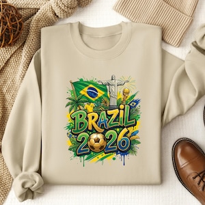 Crewneck sweatshirt with Brazil 2026 soccer graphic and Brazilian flag.