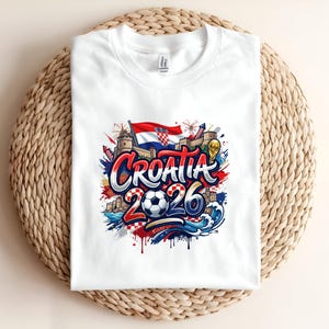 White t-shirt featuring "Croatia 2026" text with Croatian flag, castle, and waves.