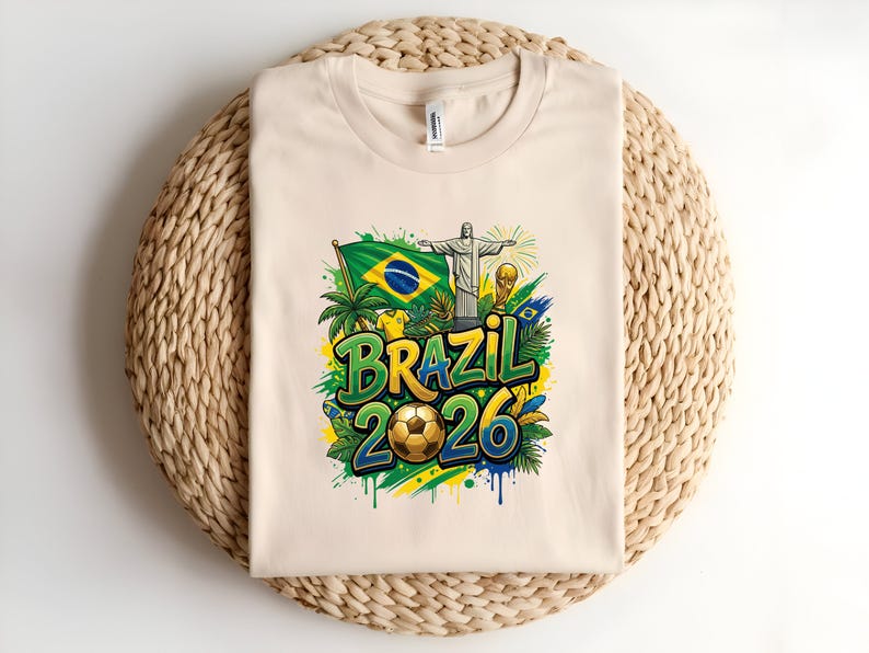 Cream t-shirt with Brazil 2026 graphic including flag, statue, and soccer ball.