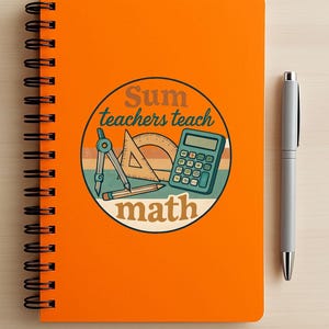 May include: Orange spiral-bound notebook with a graphic that reads "Sum teachers teach math." The graphic includes a compass, protractor, calculator, and pencil. A silver pen rests beside the notebook. The notebook is on a light wood surface.