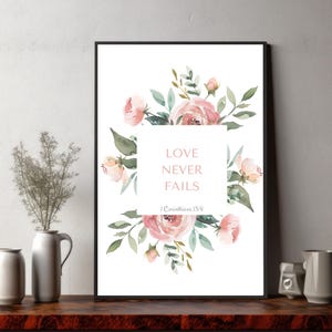 Pode incluir: Uma impressão em aquarela com flores rosa e verdes e o texto "LOVE NEVER FAILS 1 Corinthians 13:8".