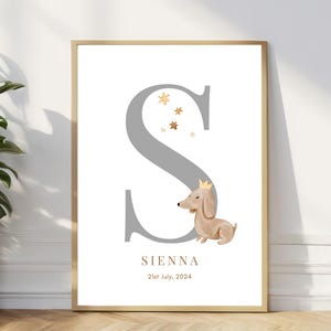 Pode incluir: Uma letra S cinza com um lindo dachshund de desenho animado usando uma coroa dourada. A letra é cercada por pequenas estrelas douradas. O texto "SIENNA" e "21st July, 2024" está abaixo da letra.