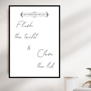 Pode incluir: Um sinal de regras de banheiro em preto e branco com o texto "Bathroom Rules" em uma fonte decorativa. O sinal diz "Flush the toilet & Close the lid".