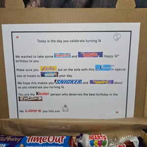 May include: A brown cardboard box filled with a variety of chocolate bars, including Wispa, Twirl, Snickers, and Kinder. The box also includes a bag of Love Hearts candies and a birthday card with the text "Today is the day you celebrate turning 16. We wanted to take some TimeOut and Wispa Happy 16th Make sure you Flake out on the sofa with this Extra special box of treats to BOOST your day. We hope this makes you SNICKER and Twirl about as you celebrate you turning 16. You are the Kinder person who deserves the best birthday in the Galaxy We LOVE you lots xxx"