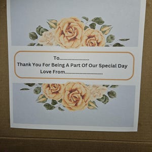 May include: A light blue card with a floral design featuring yellow roses and green leaves. The card has the text "To...... Thank You For Being A Part Of Our Special Day Love From...."
