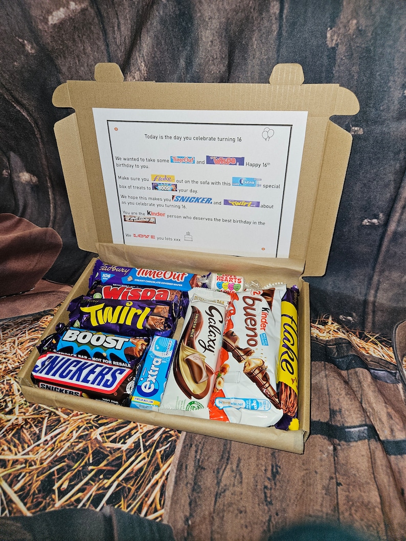 May include: A brown cardboard box filled with a variety of chocolate bars. The box has a note inside that says "Today is the day you celebrate turning 16." The note also includes the names of the chocolate bars: "Time Out", "Wispa", "Twirl", "Boost", "Snickers", "Galaxy", "Bueno", "Kinder", "Flake", and "Extra".