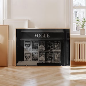 Puede incluir: Impresión en blanco y negro de un puesto de revistas Vogue vintage. La palabra "VOGUE" se muestra encima de las portadas de las revistas. Las revistas incluyen "CHANGE", "HOUSE & GARDENS", "TAEK" y "VANITY FAIR".