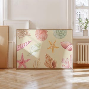 May include: A framed canvas print with watercolour illustrations of seashells and starfish in pink, beige, and green. The artwork has a light beige background and a wooden frame, evoking a coastal theme.