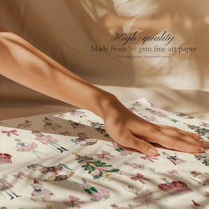 May include: A sheet of off-white fine art paper featuring a repeating pattern of nutcrackers, ballerinas, rocking horses, teddy bears, rabbits, Christmas trees, and pink bows. The text reads High-quality Made from 90 gsm fine art paper.
