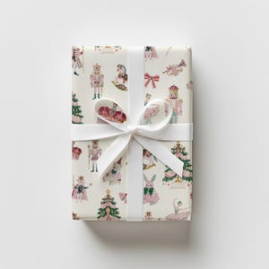 Christmas wrapping paper with watercolor nutcrackers, ballerinas, bows, rocking horses, and Christmas trees, with pastel details.