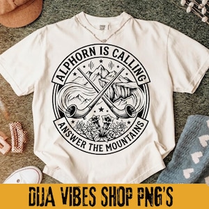May include: Cream-colored t-shirt with a circular graphic featuring crossed alphorns, mountains, and the text "ALPHORN IS CALLING ANSWER THE MOUNTAINS." The design is in black and white. The bottom of the image has the text "DIJA VIBES SHOP PNG'S."